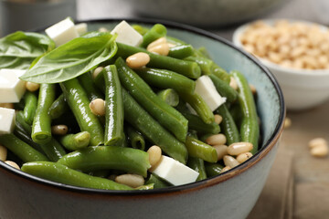 Delicious salad with green beans, pine nuts and cheese on table, closeup