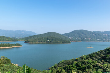 Under the blue sky, the lake is surrounded by mountains and forests