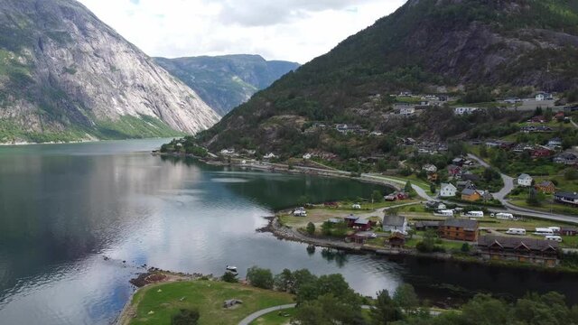 Eidfjord seafront view - Sideways moving aerial with eidfjord river and Simadalen valley in background