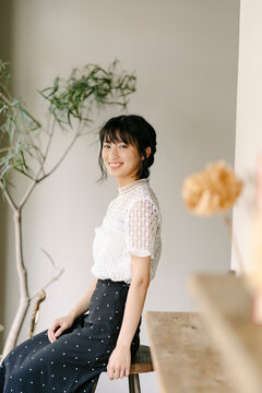 スツールに腰掛ける若い日本人女性