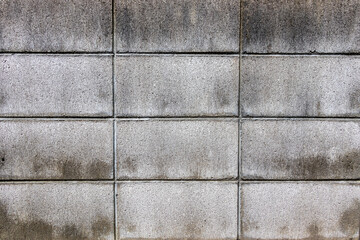 雨で濡れた灰色のコンクリートブロック塀