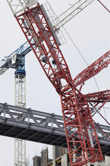 Fototapeta na wymiar Shooting a crane at a construction site. Overcast sky with gray clouds.