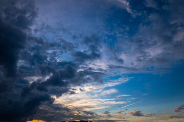 夏の終わりの夕暮れの西日と青空と暗い雲