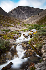 Beautiful landscape of the Khibiny mountains with rocks and a mountain stream on a summer day. Kola Peninsula, Russia. Long exposure