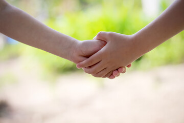 Asian girl shaking hand with child girl friend childhood background