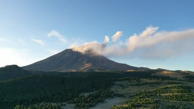 Hyperlapse of Popocatepetl volcano in Mexico throwing ash and smoke during golden hour