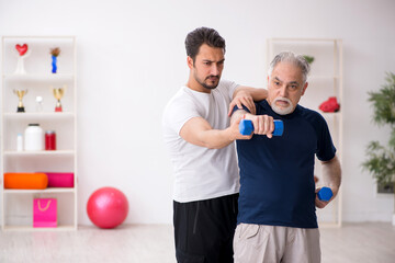 Young male instructor and old man doing sport exercises
