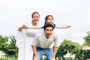 Portrait of enjoy happy love asian family father and mother holding little asian girl on back...