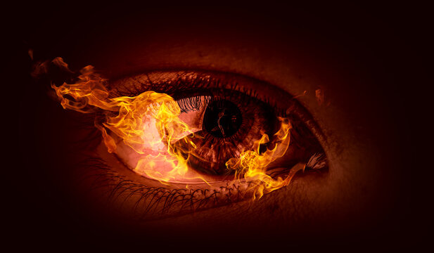 Macro image of human eye with fire flames . Mixed media