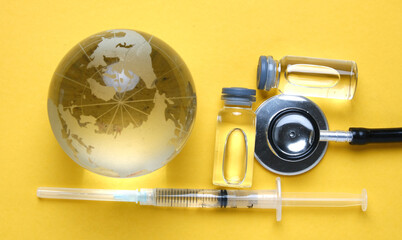 A picture of vaccine and stethoscope with glass globe insight. Take care of ousrselves during this pandemic