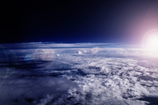 Sunrise in the stratosphere above the clouds. Flying above the clouds in the morning sunlight.
