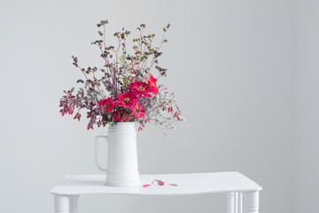 flowers in white jug on white background