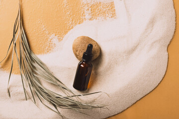 Obraz premium Serum cosmetic bottle on sand background. Abstract podium natural materials product presentation sandy background. 