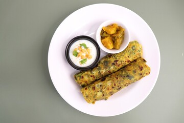 A Food called Methi paratha or Methi thepla is an Indian breakfast dish served with curd boondi...