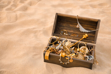 Open wooden treasure chest on sand, space for text