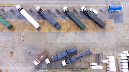 Semi Trucks in Warehouse during transportation on leading commodity. Photo of logistic from Aerial View.
