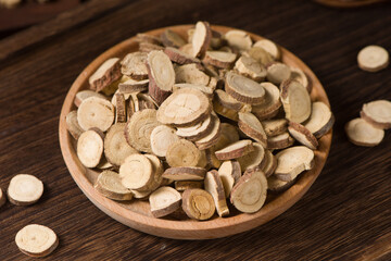 Chinese herbal medicine, sliced of dry Licorice on wooden background