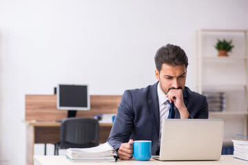 Young male employee drinking coffee during break