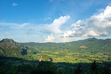 Beautiful natural view of greenery mountain slope in blue cloudy sky. Nature and outdoor parkland photo.