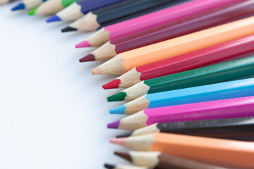 Set of colored watercolor pencils arranged in a semicircle isolated on a white background.