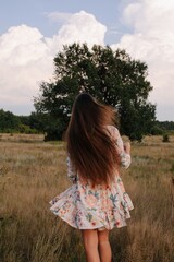 Back view unrecognizable woman with long beautiful hair at nature against big tree  - 455219257