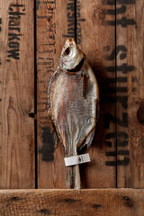 Air-dried bream with paper label on tail on rustic wooden boards