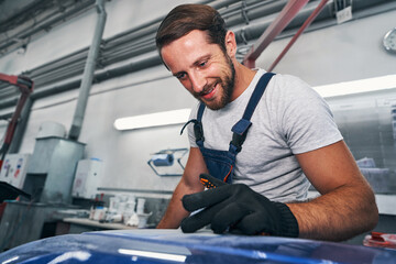 Automotive repairman checking quality of grinded surface