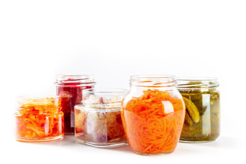 Plakat Fermented, probiotic food on a white background. Canned vegetables. Pickled carrot, sauerkraut and other organic preserves in mason jars. Healthy vegan cooking concept with copy space