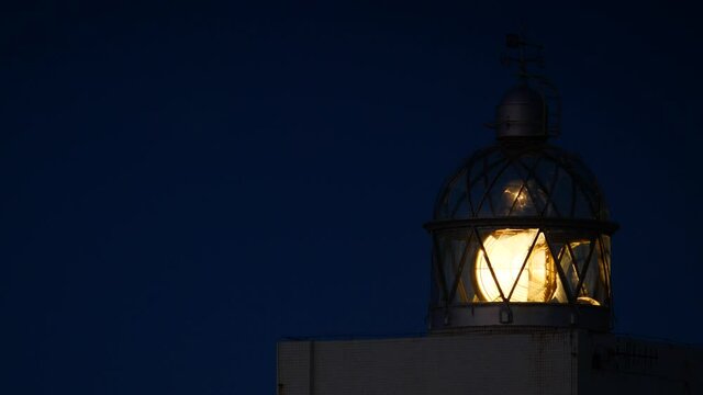 Detail view. Lighthouse with beacon light in the night. Faro Cabo Busto on Asturias coast in Spain. Tourist attraction, place to visit.