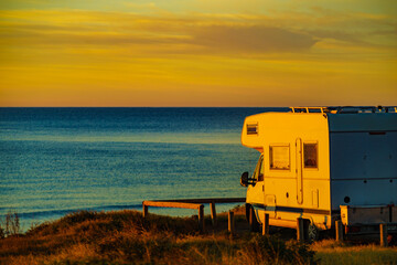 Camper vehicle on beach at sunrise