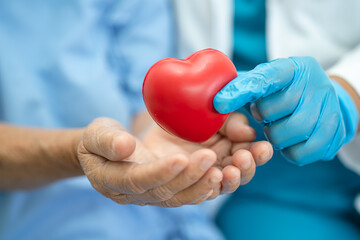 Doctor give red heart to Asian senior or elderly old lady woman patient, healthy strong medical concept