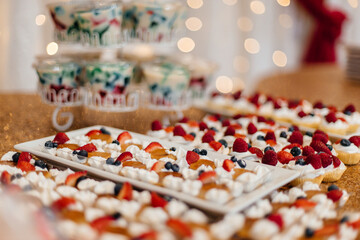 Red and gold festive decoration. Cookies, flowers, food on the birthday table. Wedding table. Festive background