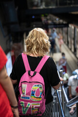 Barcelona, ​​Spain; August 25, 2021: Blonde girl with a pink backpack walking down the stairs of the subway