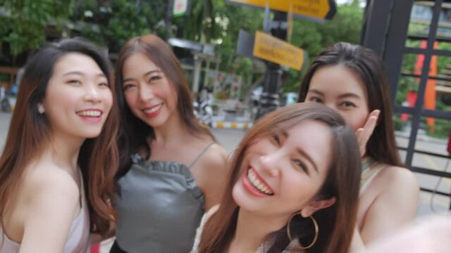 Group of young woman Asian people is taking selfie looking camera at urban city street. City lifestyle of young women group on weekend. Outdoor shopping and city lifestyle concept.
