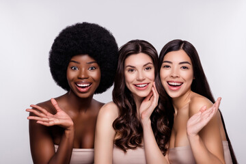 Photo of three young attractive girls happy positive smile excited enjoy skincare reaction isolated over grey color background