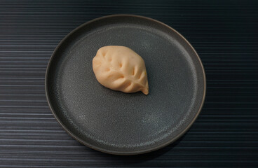 steamed fresh curry potato vegan bun orange baozi in leaf shape on dark grey wood background dim sum halal menu