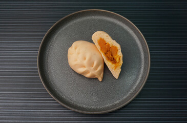 steamed fresh curry potato vegan bun orange baozi in leaf shape on dark grey wood background dim sum halal menu