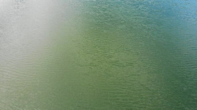 Flying Over Blue Calm Water Surface. Nature Background.