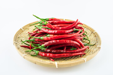 Bamboo sieve filled with fresh red peppers on white background