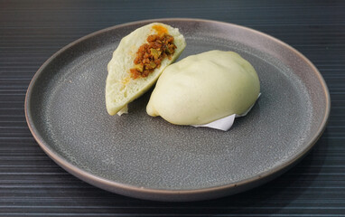 steamed fresh spicy chilli sambal petai bun green baozi in leaf shape on dark grey wood background dim sum halal menu
