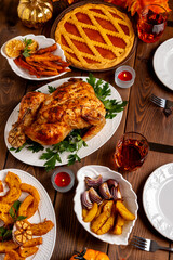 Thanksgiving Day table with turkey, pumpkin pie, roasted vegetables, top view.Thanksgiving dinner and autumn decoration.
