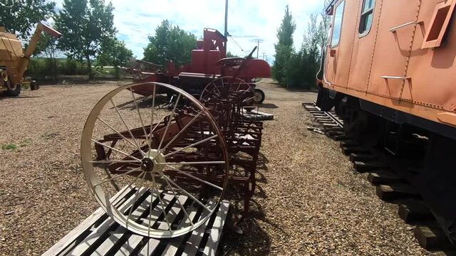 Old antique farm tools and equipment are on display in Alberta Canada next to an old train.