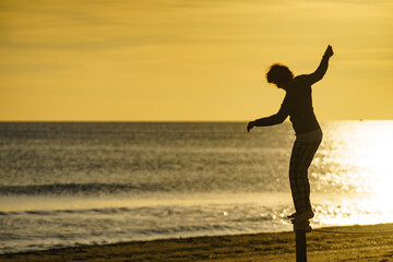 Fototapeta premium Woman having fun on beach at sunrise