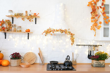 Golden leaves and a pumpkin on white kitchen in the Scandinavian style. The concept of home...