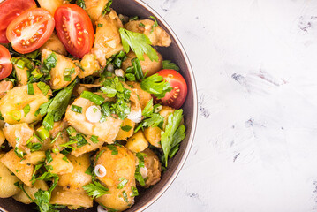 Potato salad with tomatoes in a bowl, close-up, copy space