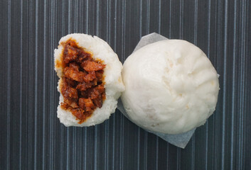 Chinese Hong Kong steamed fresh char stew marinated pork belly bun vegan bao zi in leaf shape on...