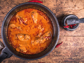 Cooking spicy chicken stew with paprika and sour cream sauce in a frying pan - chicken paprikash,...
