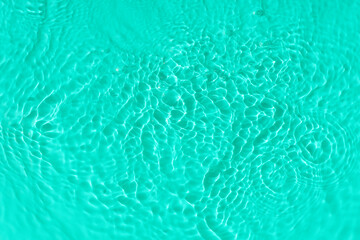 Fototapeta na wymiar Water tranquil ripple background. Water texture, circles and bubbles on a liquid blue surface. Cosmetic products and flat design concept