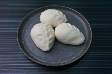 steamed fresh vegetables bun white baozi in leaf shape on dark grey wood background dim sum halal...