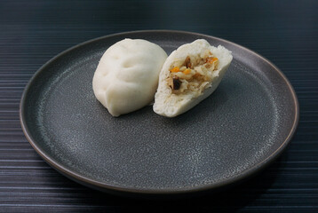 steamed fresh vegetables bun white baozi in leaf shape on dark grey wood background dim sum halal menu